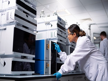 A scientist operating a CE machine for capillary electrophoresis analysis