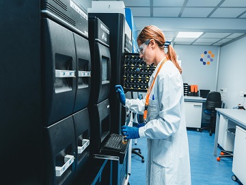 Laboratory worker operating a machine to perform disinfectant efficacy studies